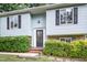 Close up of the exterior facade with a front door, neat landscaping, and a brick foundation at 2216 Lawrence Dr, Raleigh, NC 27603