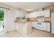 Bright kitchen featuring white cabinets, a breakfast bar, and access to an outdoor patio at 2216 Lawrence Dr, Raleigh, NC 27603