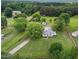Aerial view of country home on a large lot with mature trees and outbuildings at 2227 Us-15, Creedmoor, NC 27522