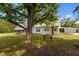Home exterior in backyard with metal roof, white siding, and mature shade trees at 2227 Us-15, Creedmoor, NC 27522
