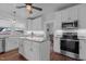 Bright kitchen with island, granite counters, white cabinets, stainless appliances and hardwood floors at 2227 Us-15, Creedmoor, NC 27522
