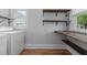 Laundry room with front load washer, dryer, natural light, and wooden shelving at 2227 Us-15, Creedmoor, NC 27522