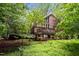 Beautiful brick home featuring a large wooden deck, surrounded by mature trees and landscaping at 224 Crawford Rd, Hillsborough, NC 27278