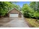 Brick home with a two-car garage surrounded by lush greenery, offering a classic aesthetic at 224 Crawford Rd, Hillsborough, NC 27278