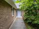 Charming brick home entrance featuring a light blue door, and manicured shrubs at 224 Crawford Rd, Hillsborough, NC 27278