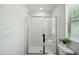 Modern bathroom featuring a glass enclosed shower with bench and a large window at 246 Spark St, Raleigh, NC 27606