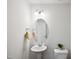 Cozy powder room with pedestal sink, oval mirror, and modern lighting at 246 Spark St, Raleigh, NC 27606