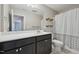 Bathroom with dark vanity, white countertop, large mirror, and decorative wood shelves at 256 Summer Ranch Dr, Fuquay Varina, NC 27526