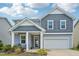 Charming two-story home with blue siding, white trim, covered porch, and attached two-car garage at 256 Summer Ranch Dr, Fuquay Varina, NC 27526