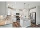 Beautiful open kitchen with stainless appliances, granite counters, white cabinets, and kitchen island at 256 Summer Ranch Dr, Fuquay Varina, NC 27526