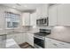 Modern kitchen featuring white cabinets, stainless steel appliances, and granite countertops at 256 Summer Ranch Dr, Fuquay Varina, NC 27526