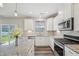 Bright kitchen with stainless appliances, granite counters, island, and sliding glass door to back yard at 256 Summer Ranch Dr, Fuquay Varina, NC 27526