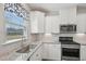 Kitchen with white cabinets, granite countertops, stainless appliances, and a window at 256 Summer Ranch Dr, Fuquay Varina, NC 27526