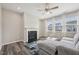 Cozy living room with fireplace, ceiling fan, hardwood floors, and large windows at 256 Summer Ranch Dr, Fuquay Varina, NC 27526