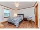 Cozy bedroom with a patterned bedspread, wood-look flooring, and natural light from the window at 2619 Steel Bridge Rd, Sanford, NC 27330