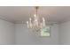 Close-up view of an elegant crystal chandelier in a dining room with laminate floors and natural light at 2619 Steel Bridge Rd, Sanford, NC 27330