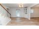 Dining area with a chandelier, white cabinets, staircase, and access to the backyard at 2619 Steel Bridge Rd, Sanford, NC 27330