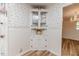 Corner built-in cabinet in a dining room space featuring charming wallpaper and laminate wood flooring at 2619 Steel Bridge Rd, Sanford, NC 27330