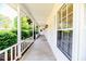 Inviting covered front porch with white pillars, decorative plants and nice shaded area at 2619 Steel Bridge Rd, Sanford, NC 27330