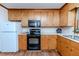 The kitchen features wood cabinets, black appliances, and a white refrigerator at 2619 Steel Bridge Rd, Sanford, NC 27330