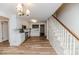 Bright kitchen with white cabinets and wood laminate flooring adjacent to staircase at 2619 Steel Bridge Rd, Sanford, NC 27330