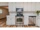 Charming kitchen featuring white cabinets and stainless steel appliances, providing a blend of classic style and modern convenience at 2619 Steel Bridge Rd, Sanford, NC 27330