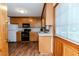 Kitchen with wooden cabinets, black appliances and wooden floors at 2619 Steel Bridge Rd, Sanford, NC 27330
