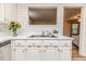 Bright kitchen features white cabinets, a double sink, and charming floral wallpaper at 2619 Steel Bridge Rd, Sanford, NC 27330