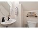 Cozy half-bathroom with a round mirror, vanity, and toilet at 270 Wembley Dr, Clayton, NC 27527