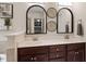 Bathroom featuring dual sinks, brown cabinetry, and decorative mirrors at 270 Wembley Dr, Clayton, NC 27527
