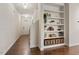 Inviting hallway featuring hardwood floors, a built-in shelving unit, and ample natural light at 270 Wembley Dr, Clayton, NC 27527