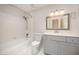 Bathroom featuring a shower and tub with white tile and a vanity with gray cabinets at 2800 Glen Burnie Dr, Raleigh, NC 27607