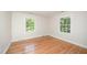 Bright bedroom featuring hardwood floors and two windows offering a view of the surrounding trees at 2800 Glen Burnie Dr, Raleigh, NC 27607