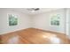 Bedroom with hardwood floors, a ceiling fan, and natural light from two windows at 2800 Glen Burnie Dr, Raleigh, NC 27607