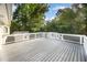 Large deck with white railings offers a scenic view of the surrounding trees and blue sky at 2800 Glen Burnie Dr, Raleigh, NC 27607