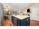 Modern kitchen with a center island, stainless steel appliances, open floor plan, and luxury vinyl plank flooring at 2822 Pickett Rd # 173, Durham, NC 27705
