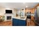 Modern kitchen with a center island, stainless steel appliances, fireplace, and luxury vinyl plank flooring at 2822 Pickett Rd # 173, Durham, NC 27705