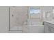 Bathroom with a soaking tub, glass enclosed shower with marble tile, and a window at 2924 Watering Hole Way, Apex, NC 27502