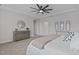 Neutral bedroom with tray ceiling, ceiling fan, and a dresser with a mirror at 2924 Watering Hole Way, Apex, NC 27502