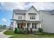 Two-story home with a front porch, stone accents, manicured landscaping and inviting curb appeal at 2924 Watering Hole Way, Apex, NC 27502