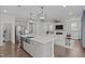 Open-concept kitchen with stainless appliances, island with sink, and view into the living room at 2924 Watering Hole Way, Apex, NC 27502
