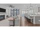 Open-concept living area with a fireplace, an adjacent kitchen, and stylish pendant lighting at 2924 Watering Hole Way, Apex, NC 27502