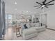 Open living space with a large sofa, kitchen, pendant lighting, and many windows at 2924 Watering Hole Way, Apex, NC 27502