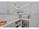 Well-organized pantry features white subway tile backsplash, beverage cooler, and ample countertop space at 2924 Watering Hole Way, Apex, NC 27502