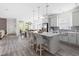 Open-concept kitchen featuring gray cabinets, a large island with seating, and modern stainless steel appliances at 306 Crossland Dr, Chapel Hill, NC 27517