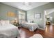 Bright bedroom featuring two beds, hardwood floors, and soft, natural light from a window at 306 Faith Dr, Gibsonville, NC 27249