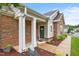 Inviting front entrance with stone accents, elegant columns, and well-maintained landscaping at 306 Faith Dr, Gibsonville, NC 27249