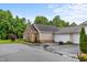 Attached two-car garage with stone and siding exterior, complemented by manicured shrubs at 306 Faith Dr, Gibsonville, NC 27249