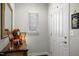 Bright foyer featuring white door, wood floors, accent table, mirror and window with blinds at 306 Faith Dr, Gibsonville, NC 27249