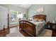 Bright main bedroom featuring a window, bed, and bedside table with lamp at 306 Faith Dr, Gibsonville, NC 27249